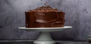 a whole chocolate fudge cake on a cake stand