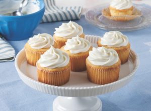 Six Vanilla Frosted Cupcakes On Cake Stand