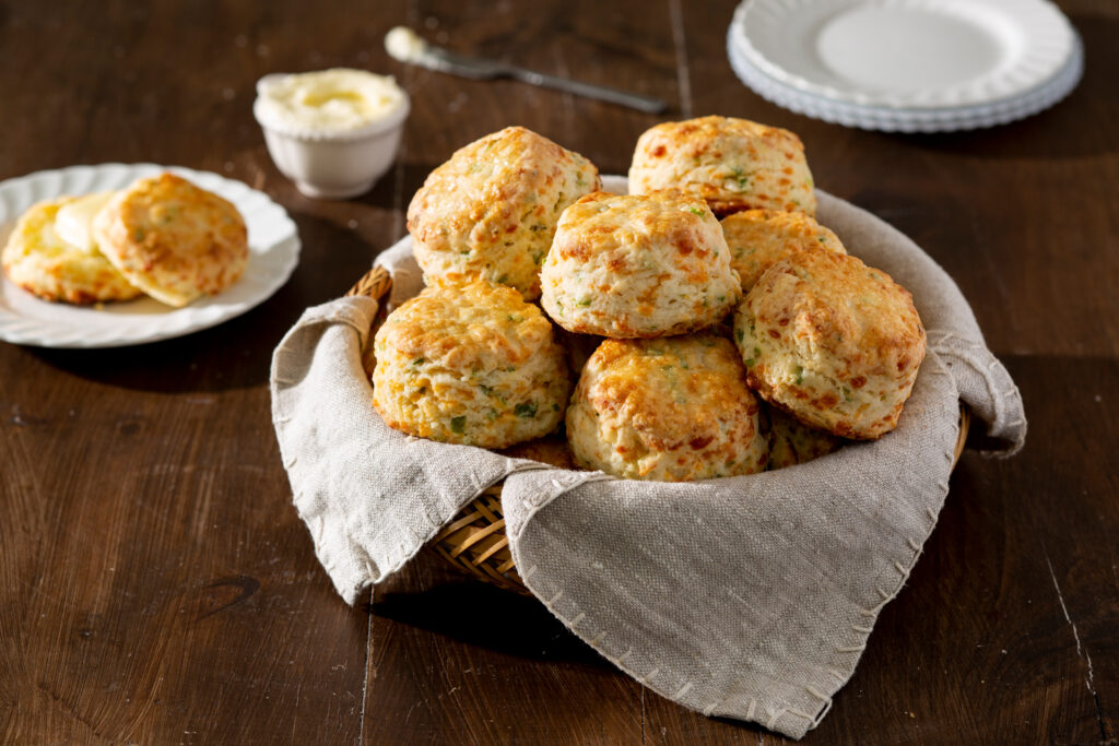 a linen lined basket of delicious homemade cheddar onion biscuits made with swans down cake flour