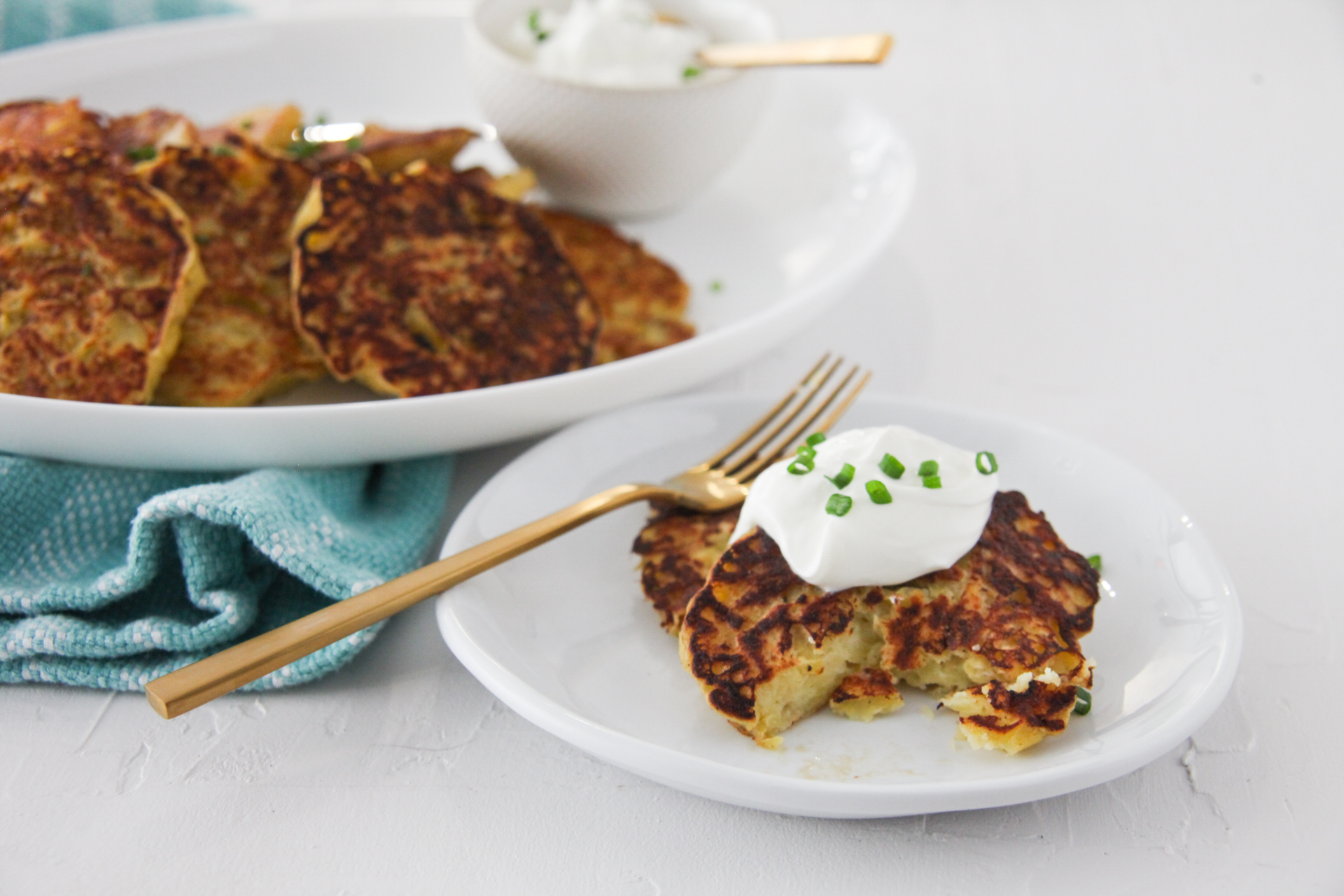Irish Potato Pancakes on a plate topped with a dollop of sour cream