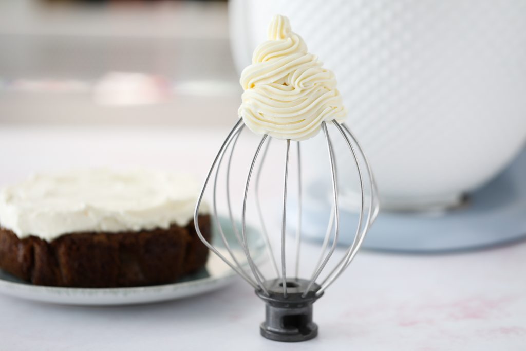 Russian Buttercream Frosting On Whisk With Frosted Cake