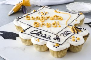 A pull-apart Cupcake Cake with white frosting, decorated for a graduation celebration