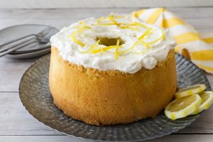 A Chiffon Cake with white icing and lemon zest curls