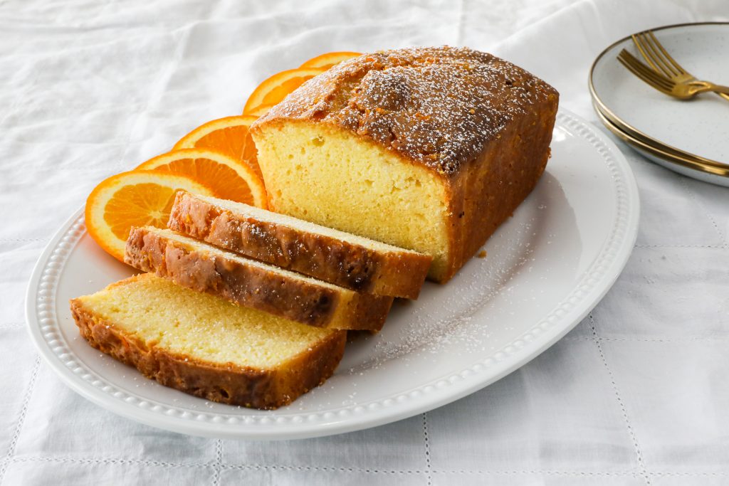 An Orange Pound Cake, sliced, on a plate