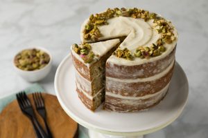 Pistachio Cake on cake stand with one slice cut out