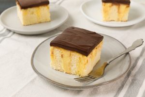 slices of Boston Cream Poke Cake on serving plates