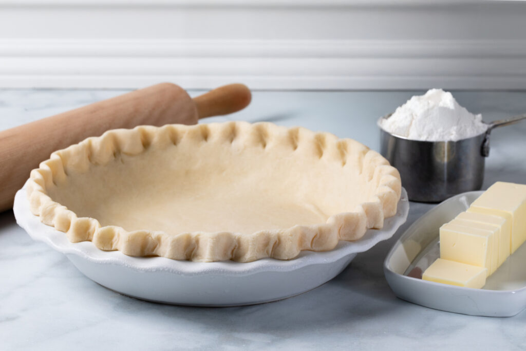 homemade pie dough in a white ceramic pie dish