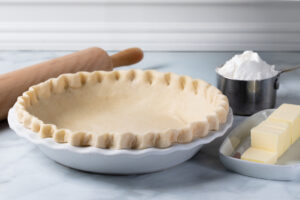 homemade pie dough in a white ceramic pie dish