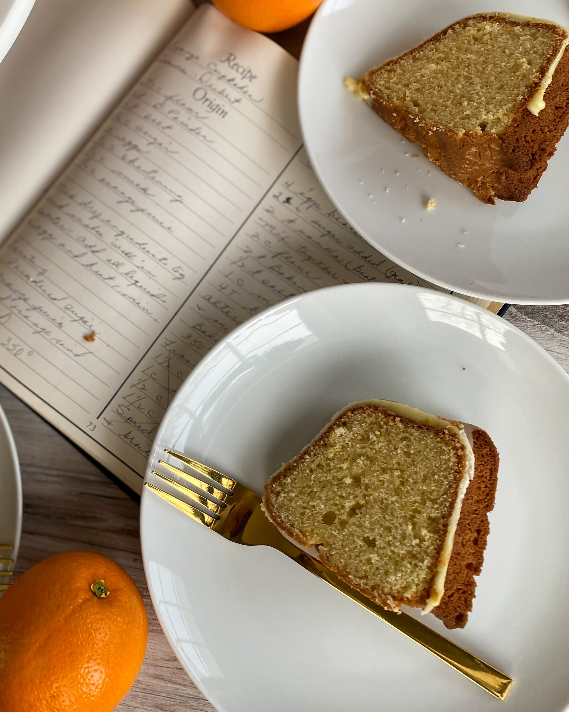 orange glazed bundt cake slice on plate with gold fork