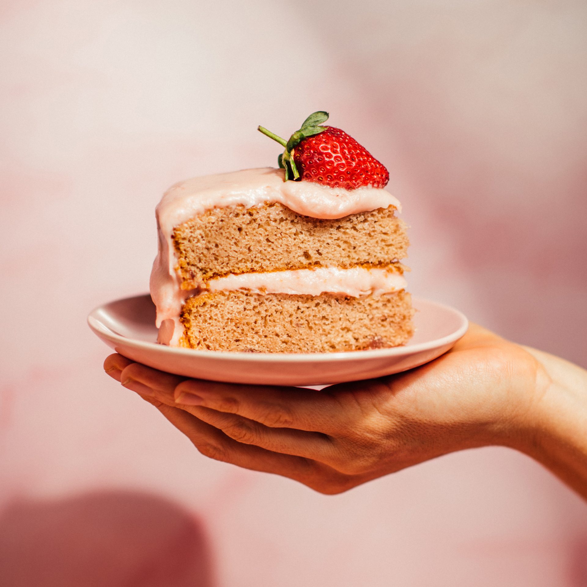 Slice of pink Strawberry Preserves Cake on white plate